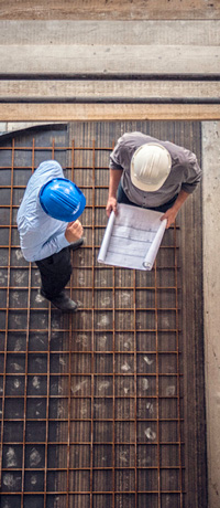 Two construction workers looking over blueprints